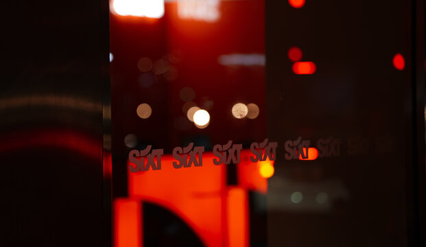 The logo sign of Sixt rent a car company during the night. Car rental industry. London, United Kingdom, 2022.
