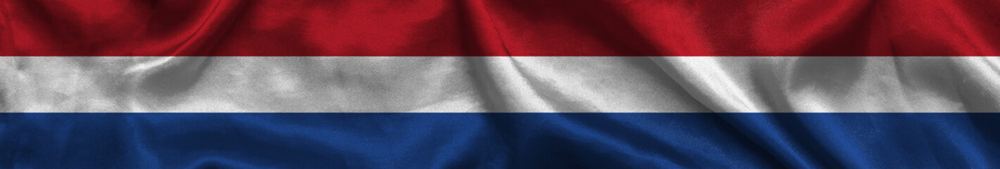 Elongated national flag of Netherlands with a fabric texture fluttering in the wind. Dutch flag for website design. 3d illustration
