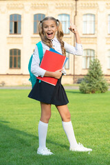 Excited girl making winning gesture, school. Happy teenage girl in school uniform celebrating victory