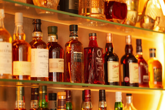 Whiskey and a lot of premium alcoholic drinks bottles in a bar like Highland Park, Glenlivet, Glefarclas or Aberlour. Fine drinks industry.