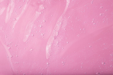 Macro photography of bubbly smear on raspberry pink background.
