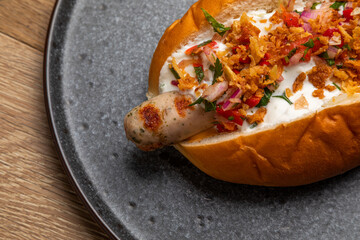 hot dog with grilled sausage, fried onion and pickled vegetables