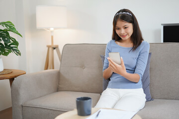 Work from home concept, Business women is reading data on smartphone while working remotely at home