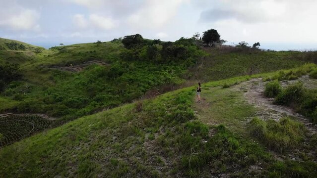 Aerial HD drone footage of woman wondered by little hill formations on top of Nusa Penida Island, Bali, Indonesia.
Parallax movement, mid angle.