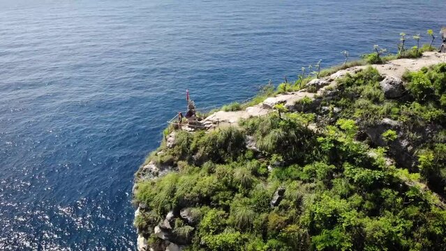 Aerial HD drone footage of woman at incredible viewpoint with sea cliff's, little islands and beaches in the back at Nusa Penida island, Bali, Indonesia.
Parallax movement, low angle.