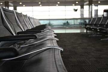 Blue chairs in a waiting area of a major airport. Sit back and relax between connecting flights.