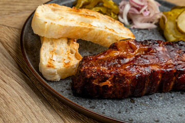 meat cooked in a smokehouse with bread and pickled cucumbers