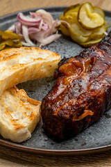meat cooked in a smokehouse with bread and pickled cucumbers