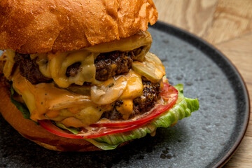 juicy burger with two meat patties and fresh vegetables