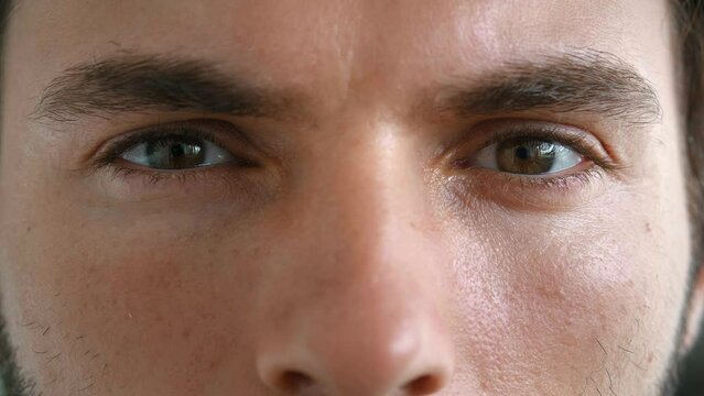 Cropped face portrait of a 30 years old male model, Caucasian man with mysterious gaze and powerful brown eyes, looking mysteriously at the camera. The window to the soul