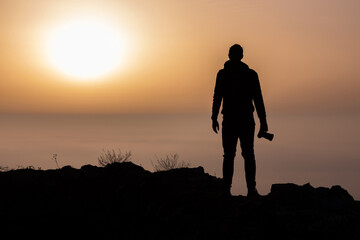 Silhouette of photographer above the morning inversion