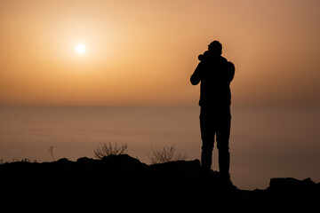Silhouette of photographer above the morning inversion