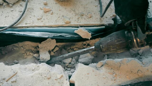 The work of a builder with a perforator close-up. Dismantling of the concrete surface