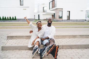 Happy black couple hugging on stairs and smiling at camera