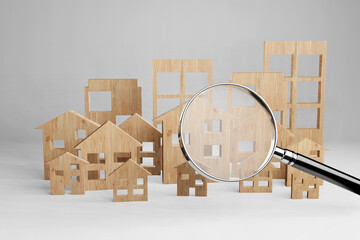 Magnifying glass in front of different types of wooden houses and apartment buildings. 3D illustration of the concept of searching for suitable houses and homes