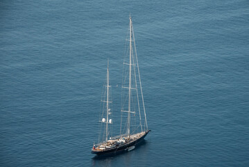 High angle view of yacht with big mast moving on sea. Nautical vessel at beautiful Mediterranean...