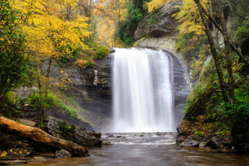 Fototapeta na wymiar Looking Glass Falls waterfall in North Carolina surrounded by a beautiful autumn forest. 