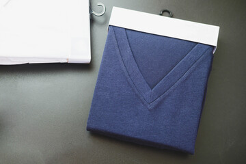 Dark blue v-neck shirt in packaging. Shopping, fashion, clothes style concept