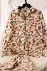 Colorful pajamas on a hanger on a light background.