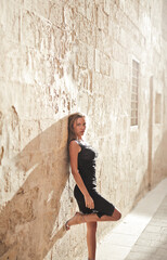 beautiful model leaning against a wall in mdina, malta