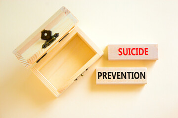 Suicide prevention symbol. Concept words Suicide prevention on wooden blocks. Beautiful white table white background. Empty wooden chest. Psychological and suicide prevention concept. Copy space.