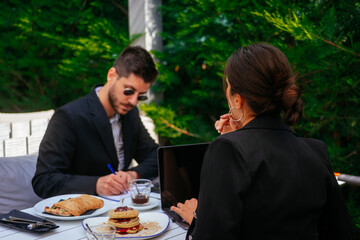 A handsome businessman and gorgeous businesswoman having breakfast early in the morning