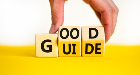 Good guide symbol. Concept words Good guide on wooden cubes. Businessman hand. Beautiful yellow table white background. Good guide and business concept. Copy space.