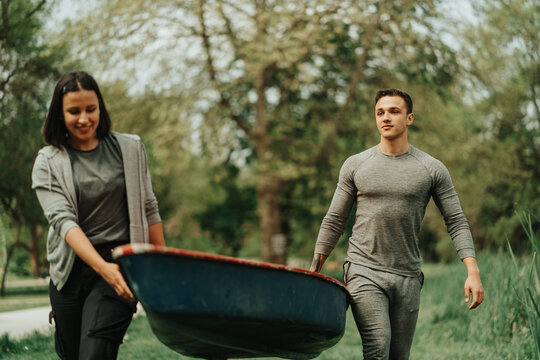 Close Up Of Couple Carrying The Red Kayak