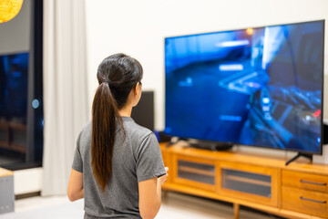 Woman play video TV game at home
