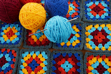 Granny squares. Crocheting supplies, colored wool yarn and knitting crocheting