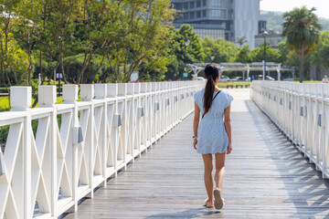 Travel woman walk on the white wooden bridge