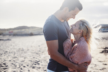 Happy couple in love outdoor smiling and hugging each other in relationship. Adult man and young...