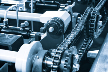 Gear chain drive shaft in conveyor belt is on production line. Timing chain of car, tensioners in engine. Industrial roller chain, technology. Team work, business industrial concept