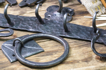 Metal forged products on a wooden background, a pike and an awl are sharp