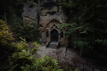 Ancient and abandoned rock chapel hidden in deep forest in the north Bohemia. Place full of creepy and haunted atmosphere.