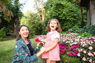 Obraz premium daughter and mother playing with a flower in the park
