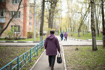 Old woman on street. Pensioner walks through city. Grandmother in Russia.