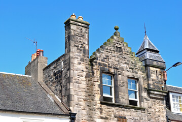 Old Stone Building with Chimneys seen against Blue Sky