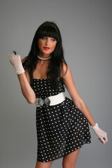 Portrait of a beautiful fashion girl brunette in the studio in dress peas retro 80s 90s vintage  on...