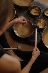 Obraz premium Women using singing copper bowl. Yoga, relaxation and meditation. Sound therapy, alternative medicine