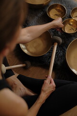 Women using singing copper bowl. Yoga, relaxation and meditation. Sound therapy, alternative...
