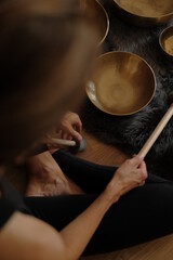 Women using singing copper bowl. Yoga, relaxation and meditation. Sound therapy, alternative medicine