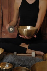 Women using singing copper bowl. Yoga, relaxation and meditation. Sound therapy, alternative medicine