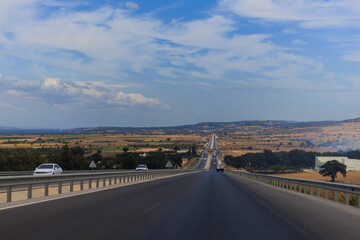 Fototapeta premium Highway wide road, transport and blue sky with clouds on a summer day
