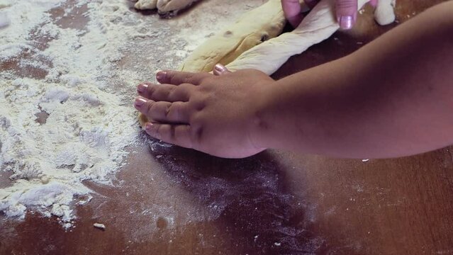 A Jewish woman's hands weave a challah in the form of a pigtail. Medium plan