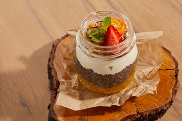dessert with white soufflé jam and seeds on a wooden table