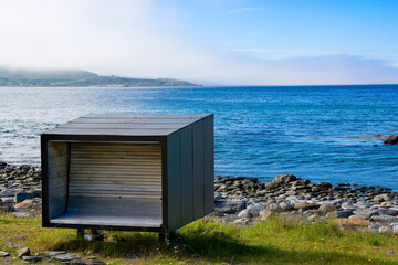 Obraz na płótnie Canvas Bench providing shelter from wind on the coast of Snefjorden, Norway
