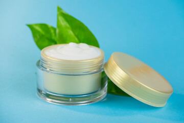 face cream in a jar cosmetic for skin with green plant leaf