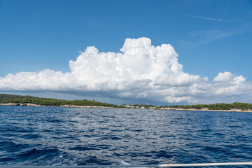 Kroatische Küstenlandschaft mit Meer im Vordergrund und Wolken am Himmel