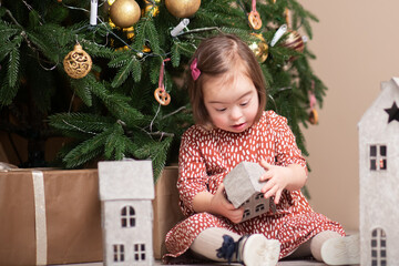 merry christmas and happy new year,child with down syndrome plays under christmas tree